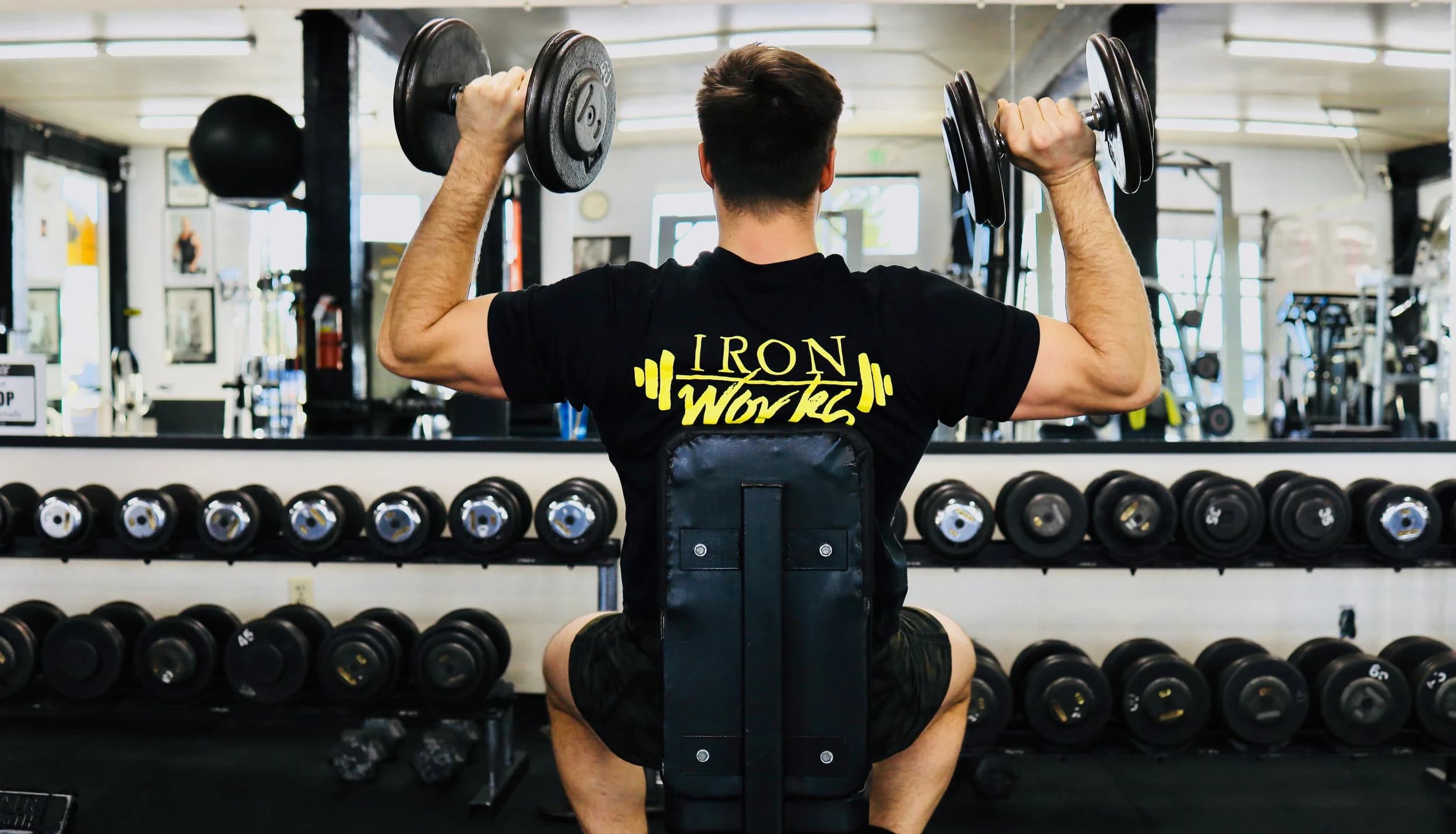 Member performing shoulder press